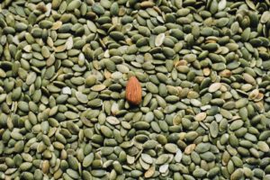 almond seed on top of green seeds